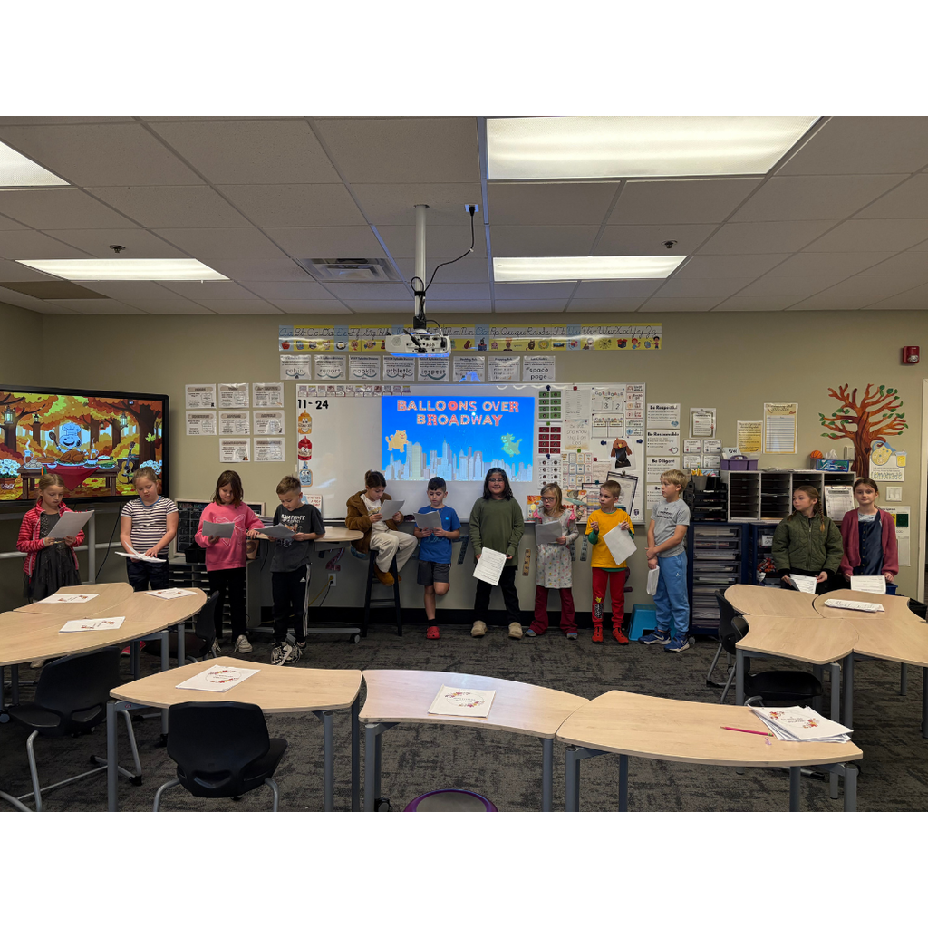 students in front of a classroom performing a readers theater