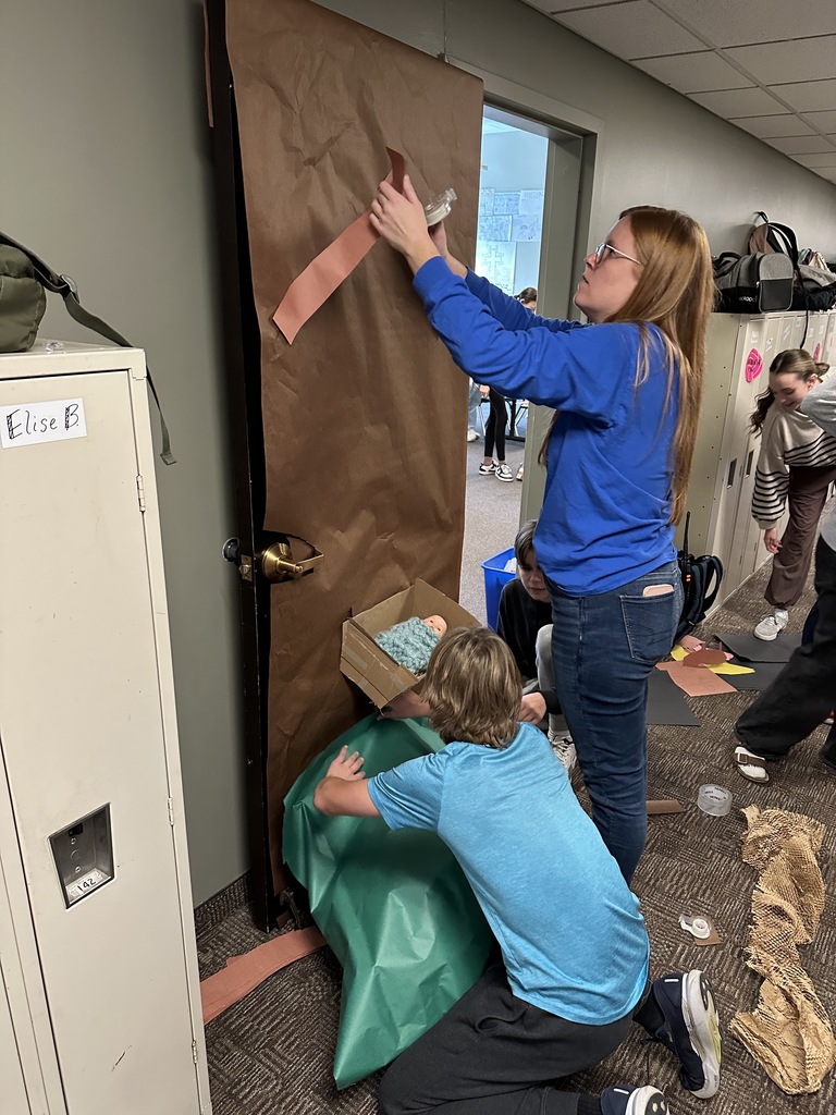 middle school students decorating a classroom door with a Christmas theme