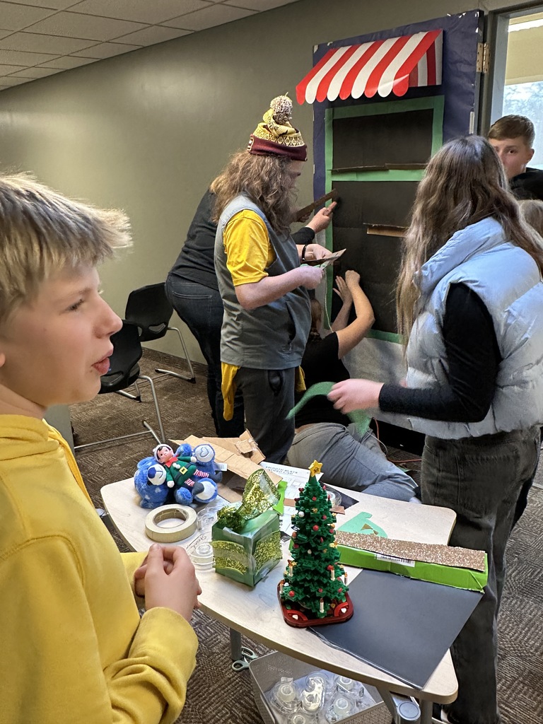 middle school students decorating a classroom door with a Christmas theme