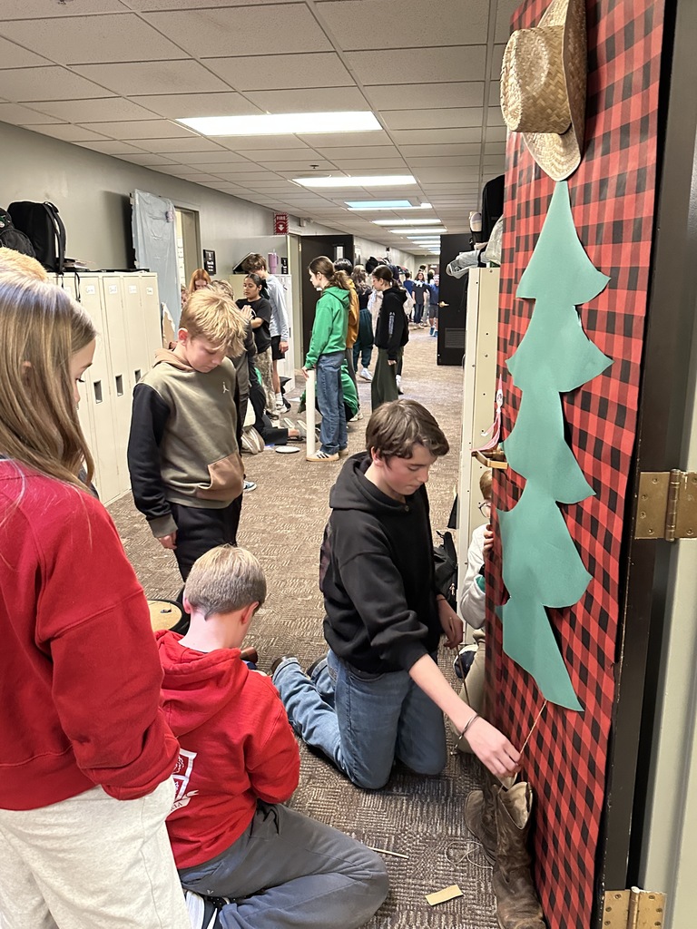 middle school students decorating a classroom door with a Christmas theme