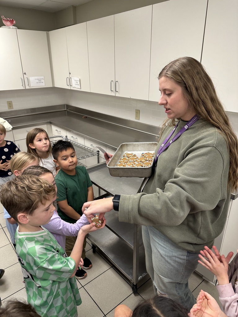teacher passing out cookies to her students