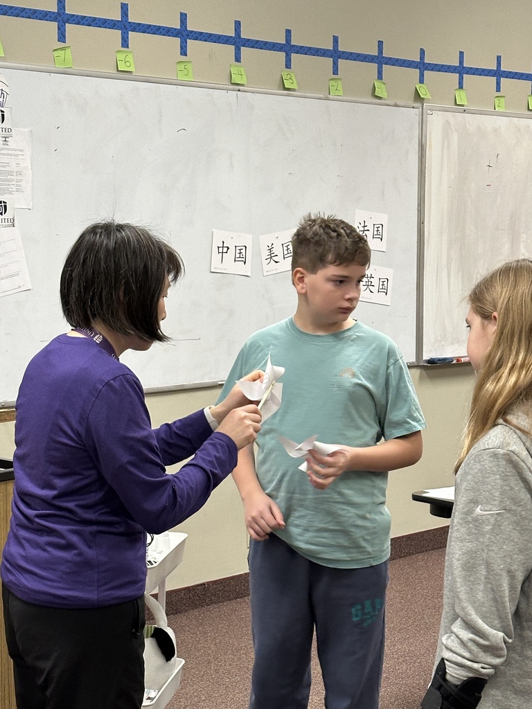 Chinese teacher helping her students put together a windmill