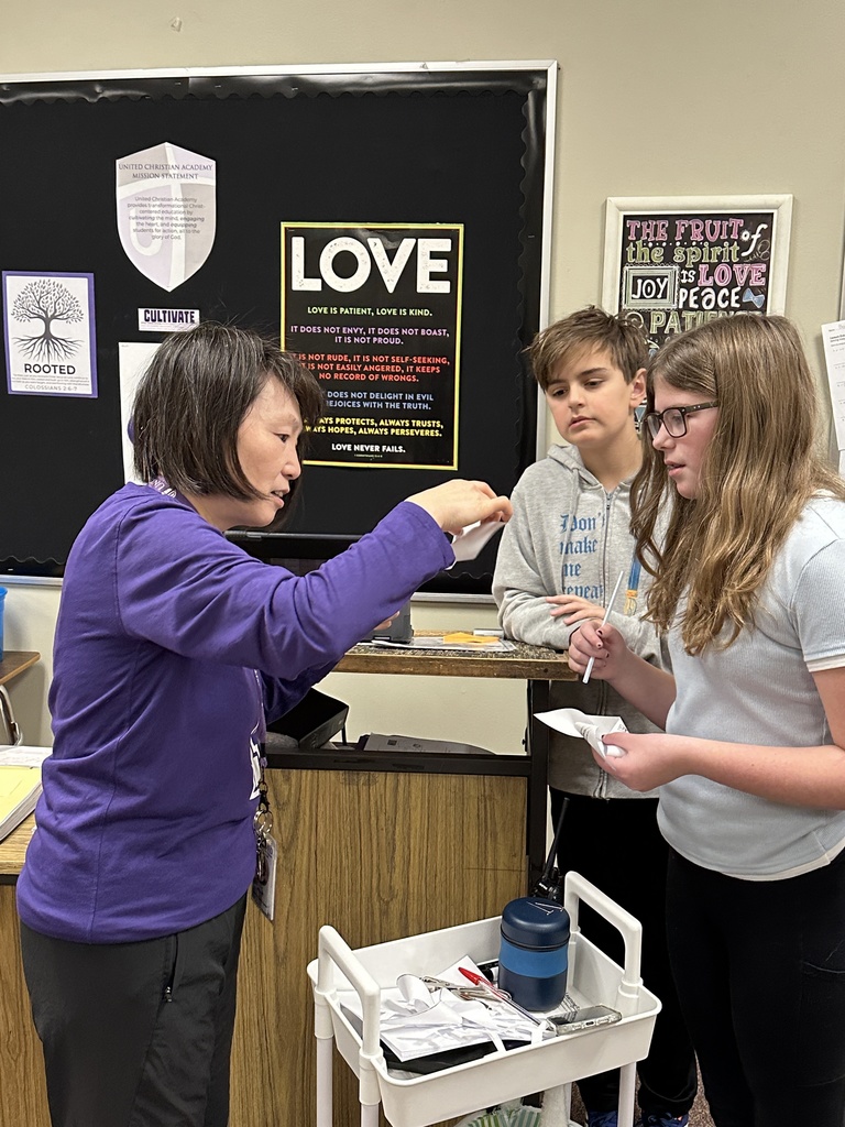 Chinese teacher helping her students put together a windmill