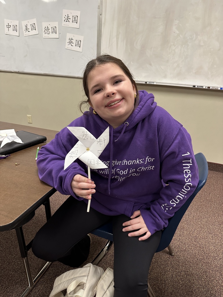 one student showing the windmills they made with Chinese characters written on them