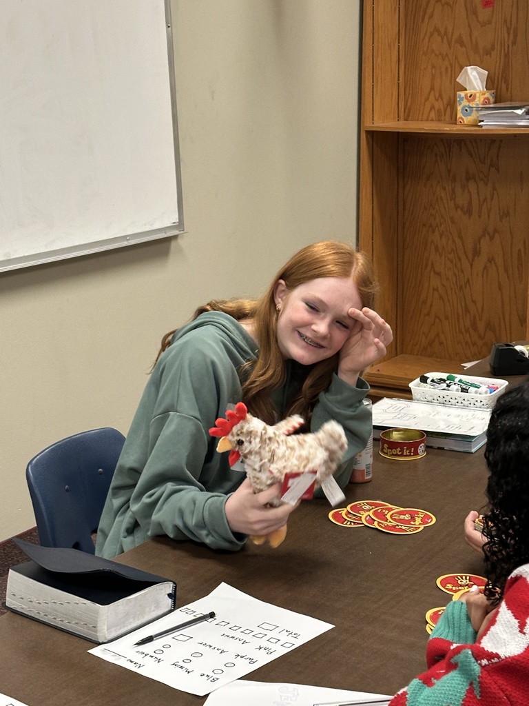 student laughing at her stuffed chicken toy