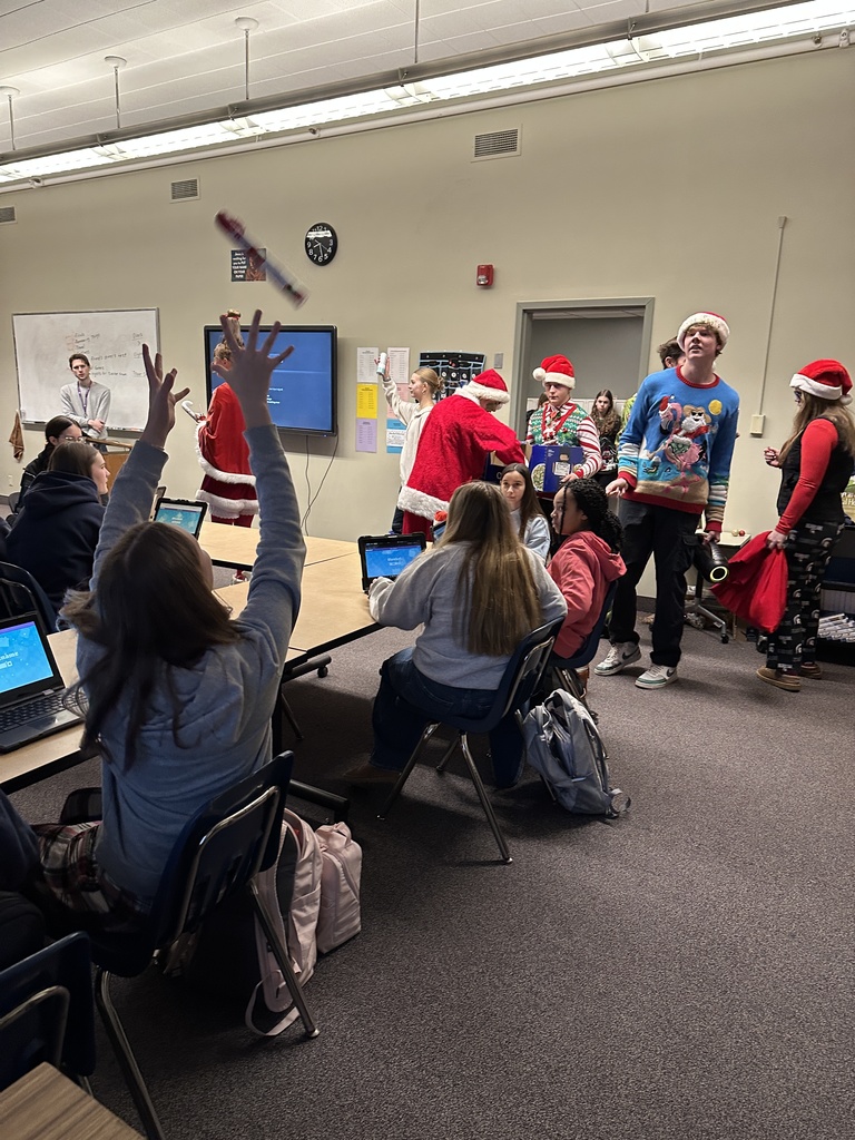 High school students handing out christmas gifts to younger students