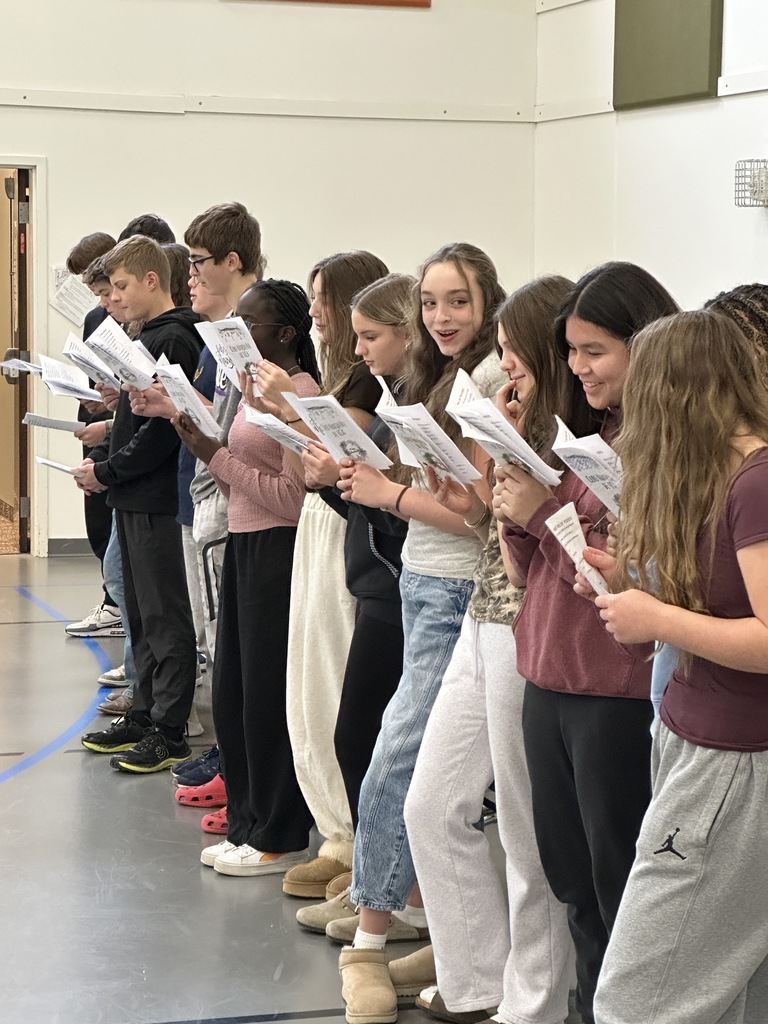 middle school spanish students signing christmas carols in spanish to kids in the lunchroom
