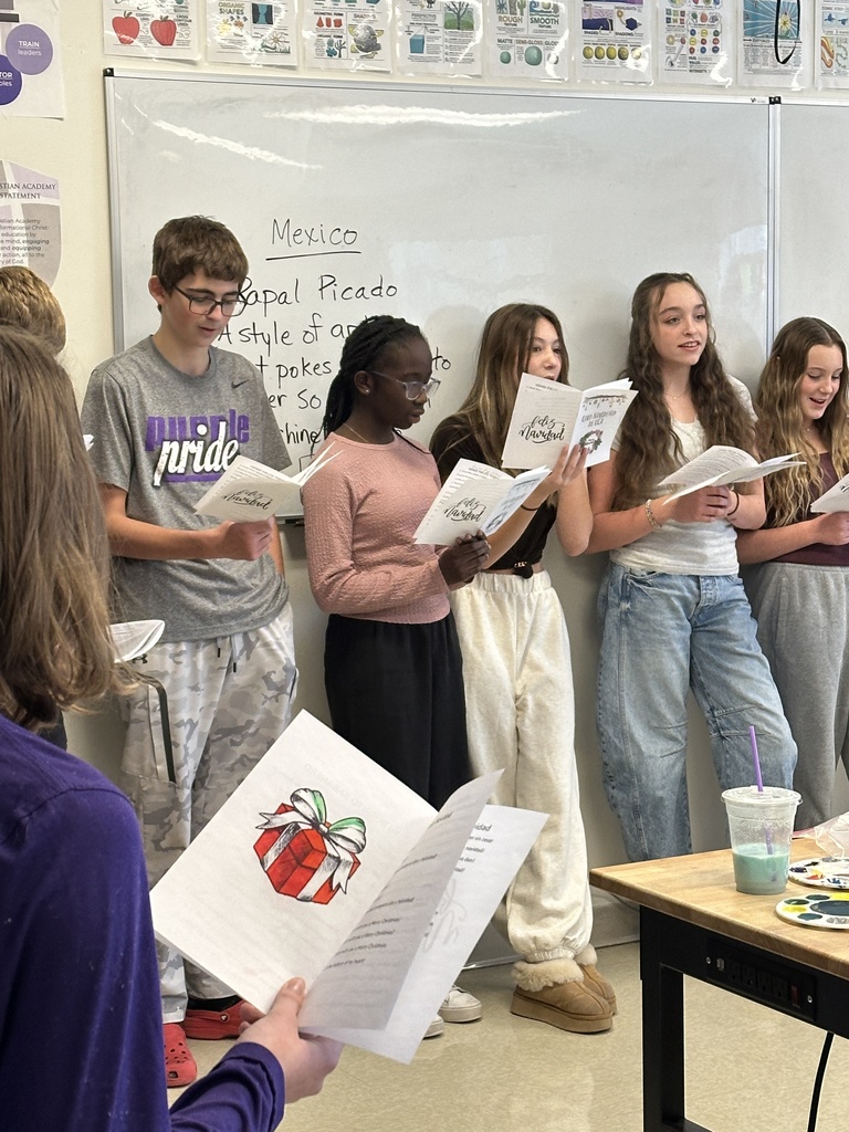 middle school spanish students signing christmas carols in spanish to other classrooms
