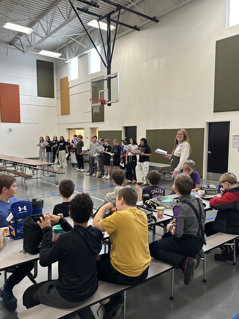 middle school spanish students signing christmas carols in spanish to kids in the lunchroom