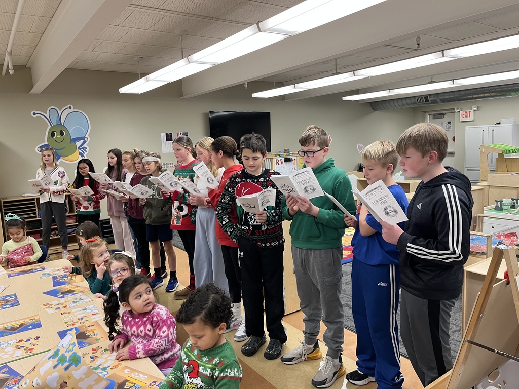 middle school spanish students signing christmas carols in spanish to other classrooms