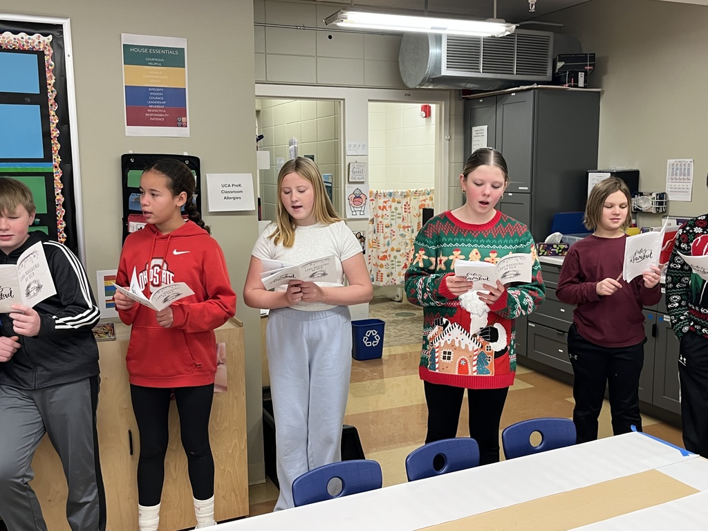 middle school spanish students signing christmas carols in spanish to other classrooms