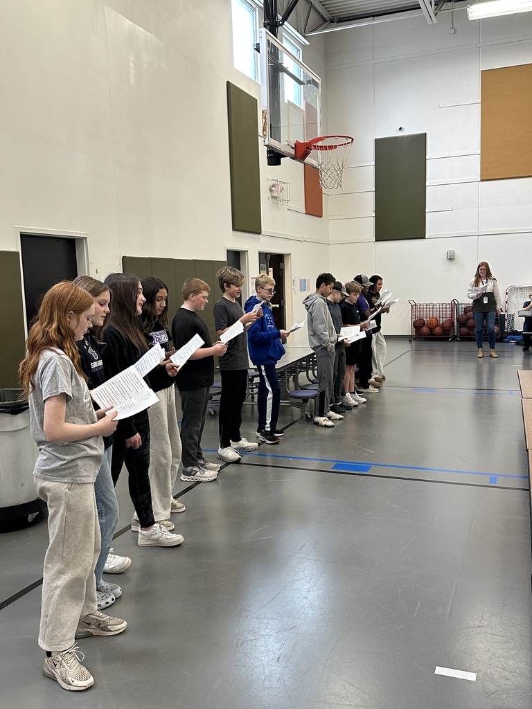 middle school spanish students signing christmas carols in spanish to students in the lunchroom