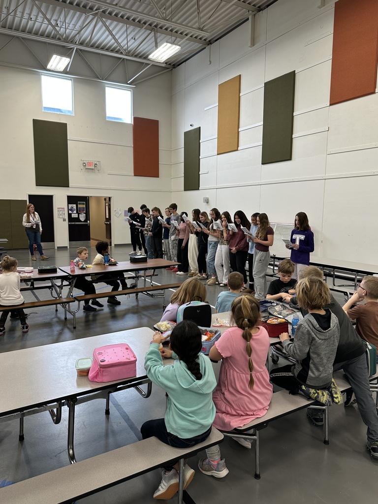 middle school spanish students signing christmas carols in spanish to kids in the lunchroom