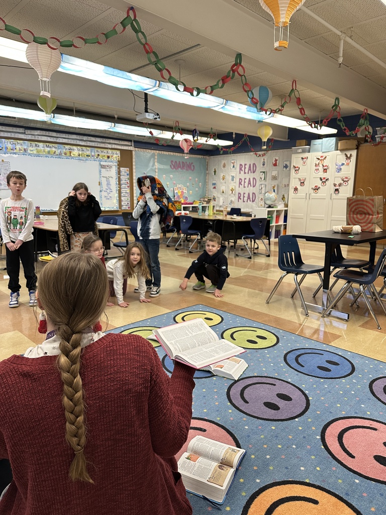 teacher sitting on the floor while teaching a Bible lesson