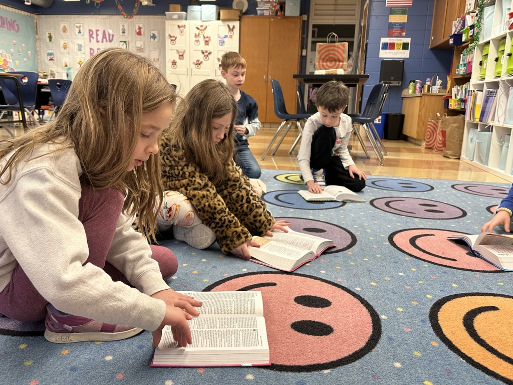 students sitting on the floor reading their Bibles