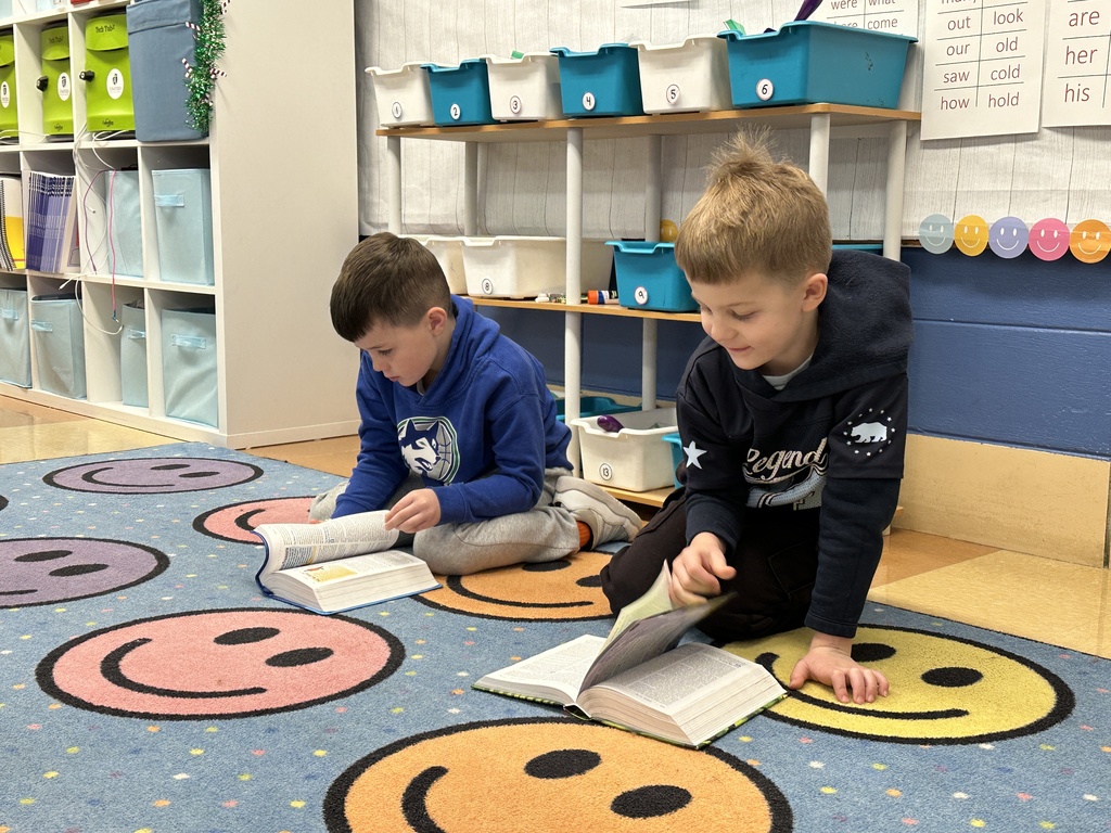 two boys sitting on the floor looking in their bibles