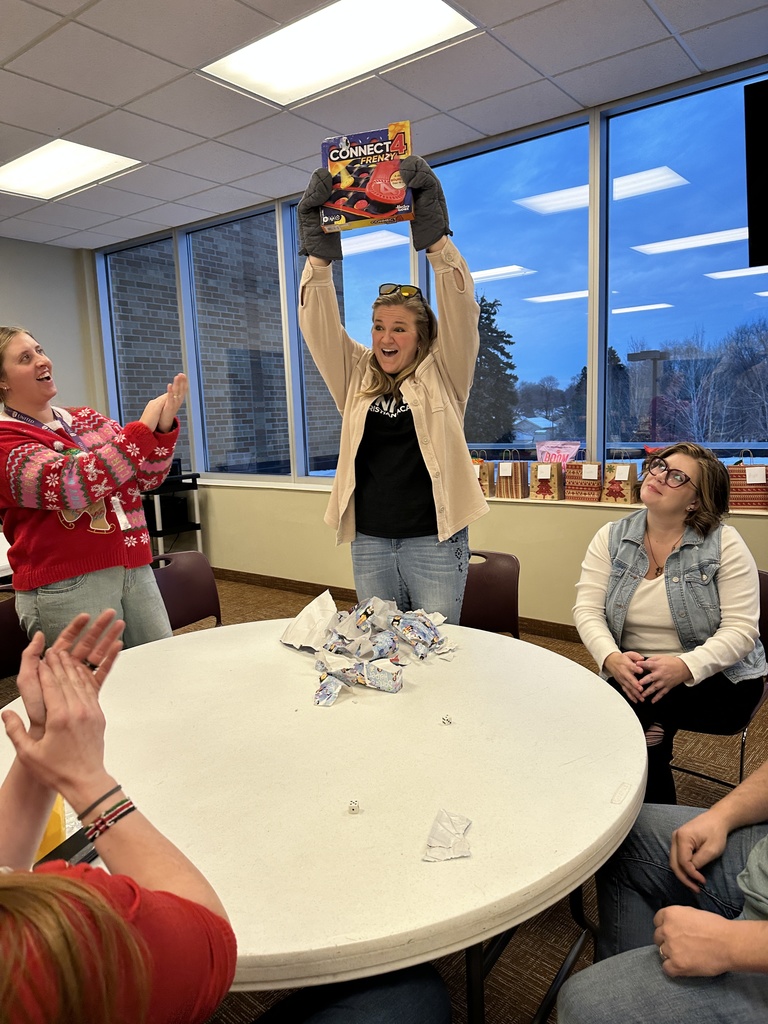 staff member holding up the gift she unwrapped with a very excited expression