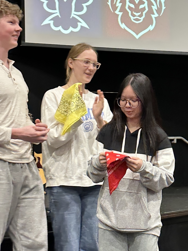 student holding a red handkerchief that signifies which house she has been assigned to 