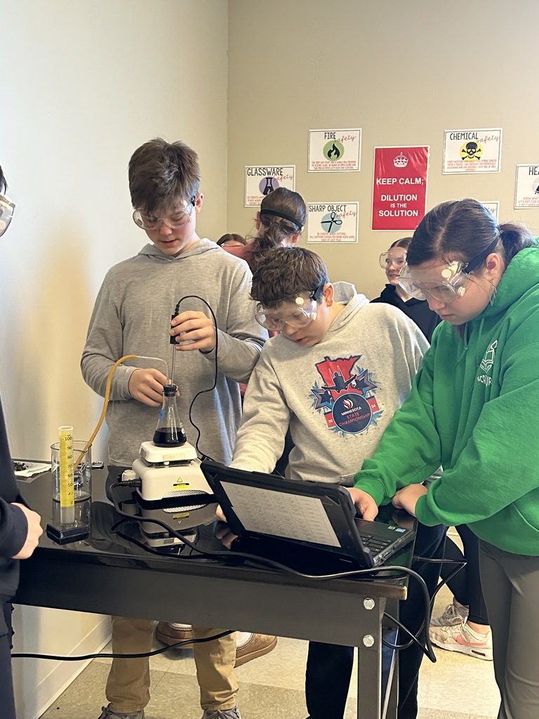 group of students at a lab station performing an experiment