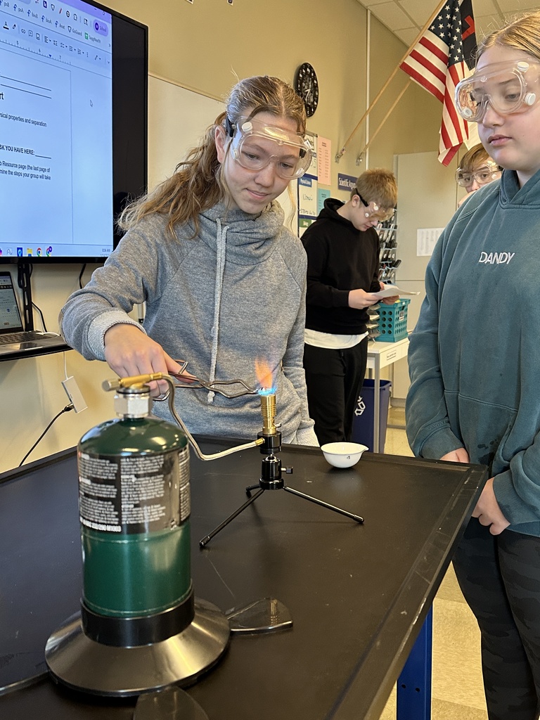 two female students performing flame tests in science class