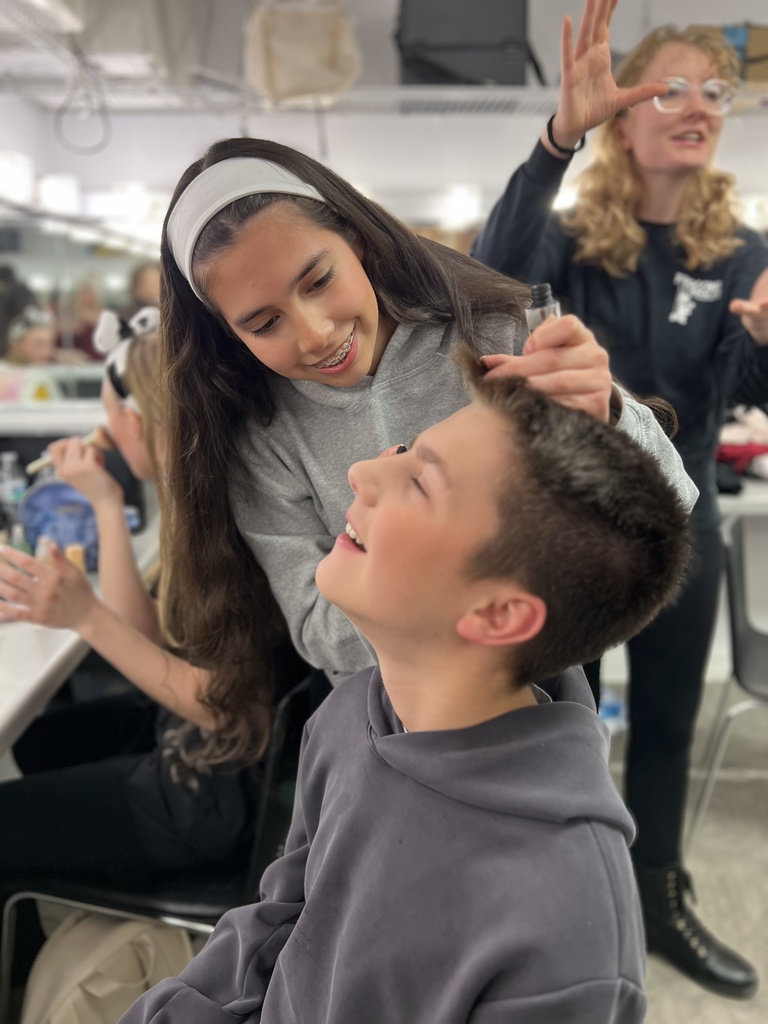actors putting on make-up before a performance in the green room