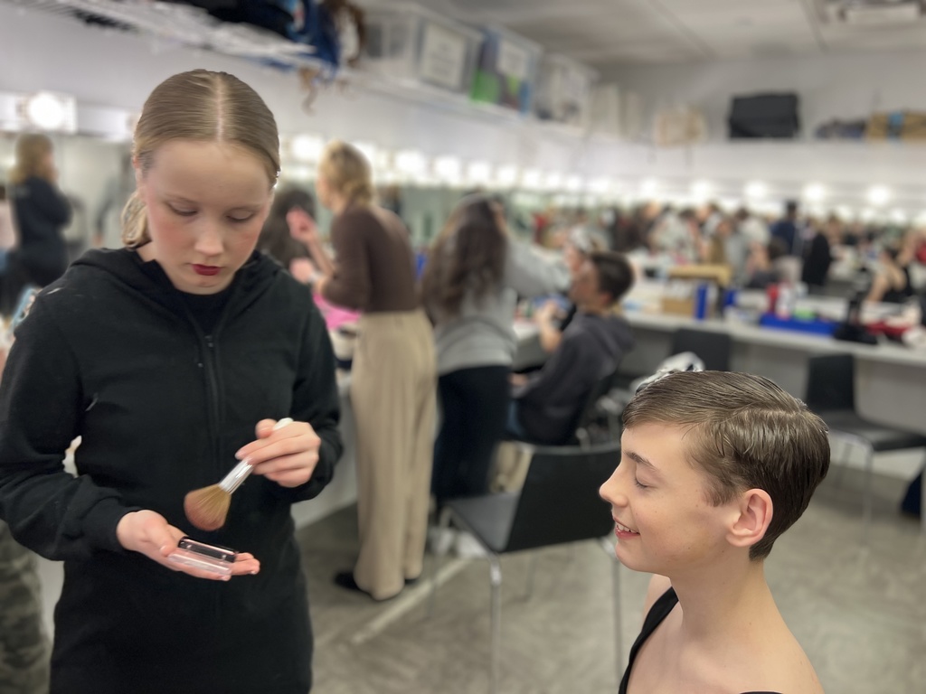 actors putting on make-up before a performance in the green room