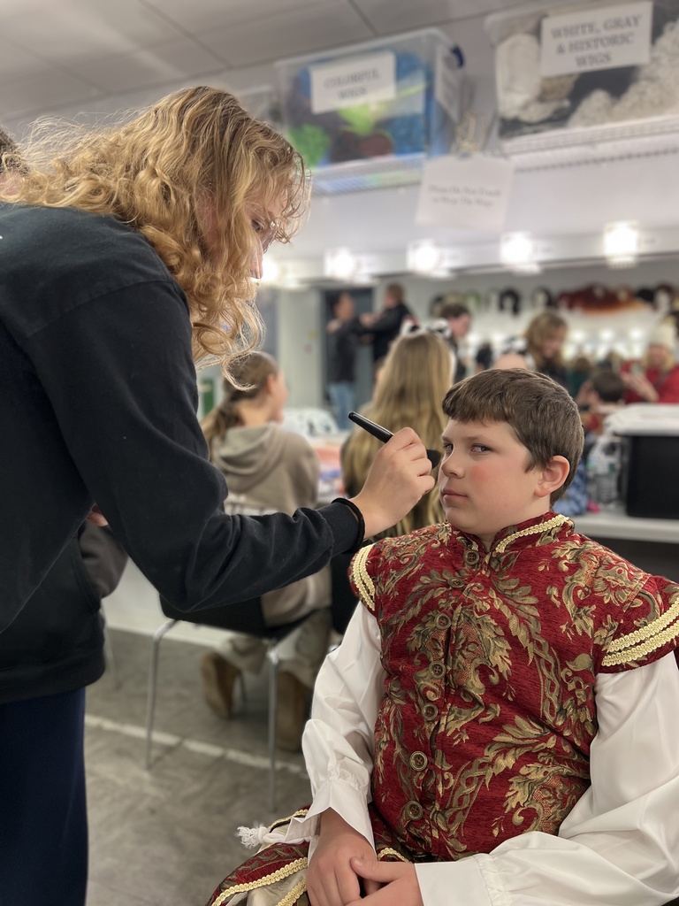 actors putting on make-up before a performance in the green room
