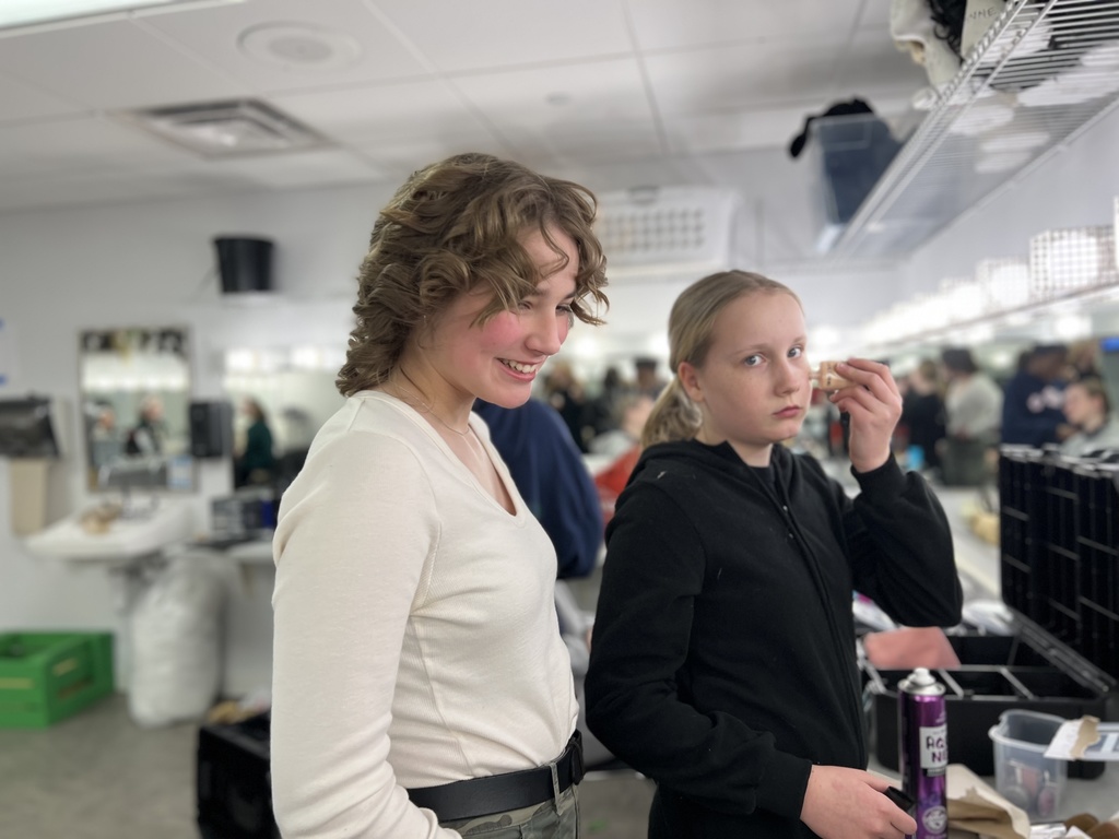 actors putting on make-up before a performance in the green room