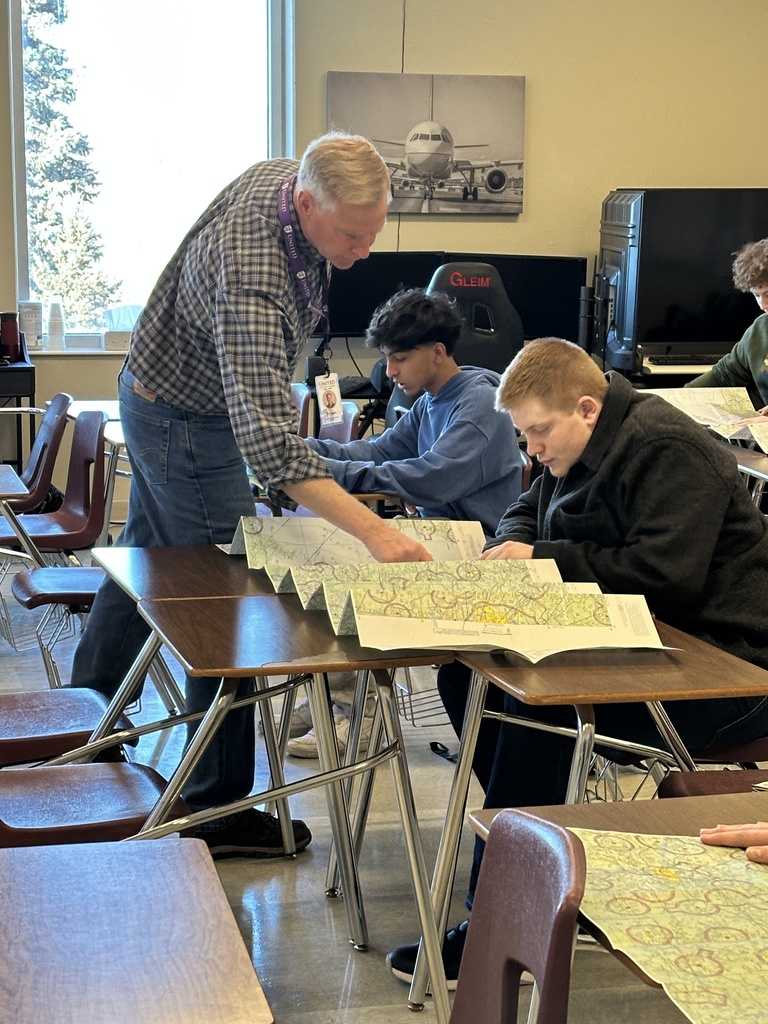 aviation teacher looking at airspace maps with students