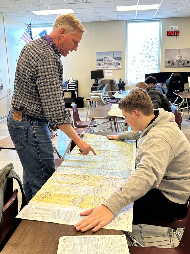 aviation teacher looking at airspace maps with students