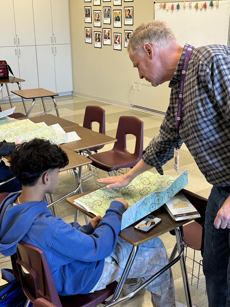 aviation teacher looking at airspace maps with students