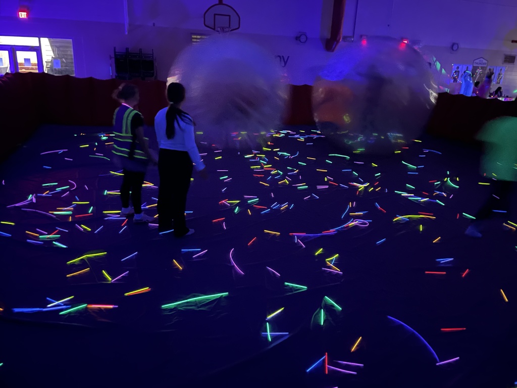 high school students playing zorb wars in the black lights