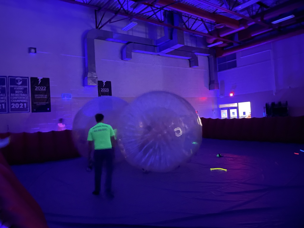 high school students playing zorb wars in the black lights