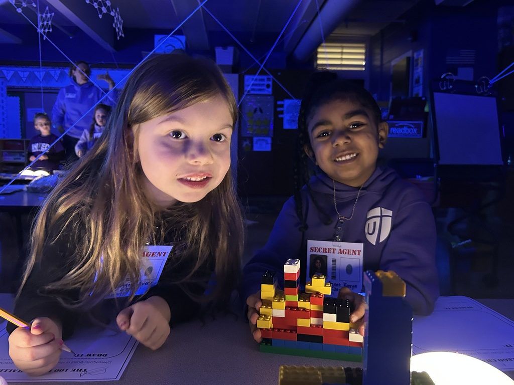 two kindergarten girls playing a game with legos