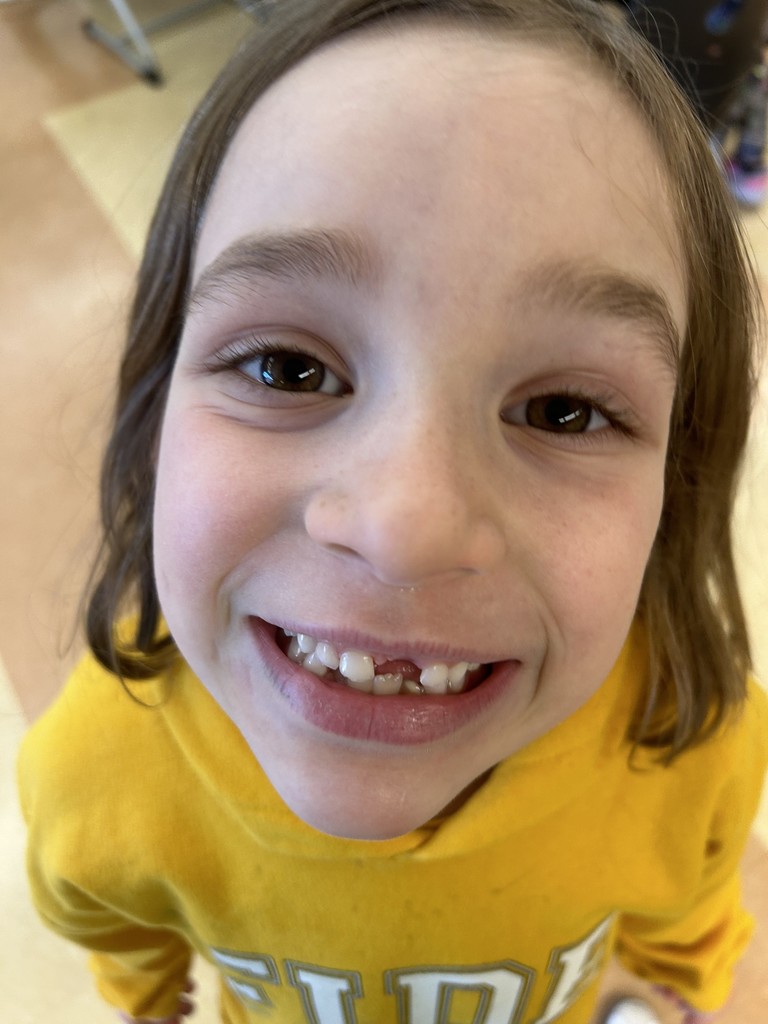 close up picture of a first grader smiling and showing her teeth