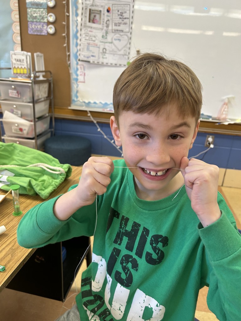 first grade student brushing his teeth