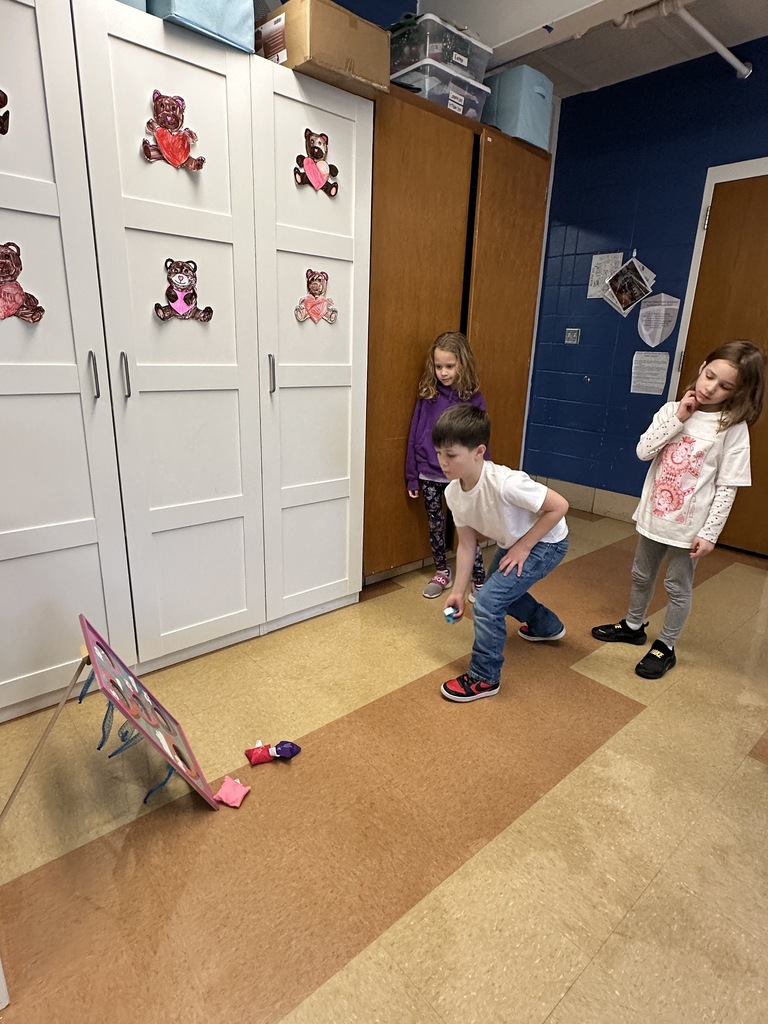 1st graders playing a bean bag toss game