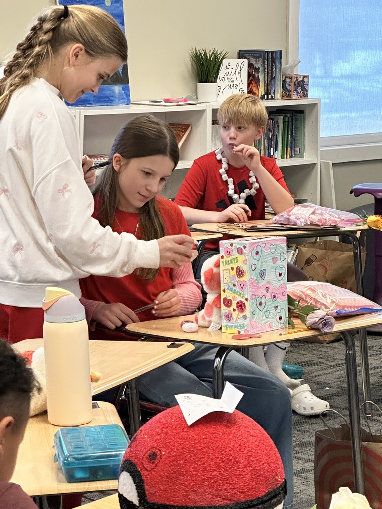 students eating candy and looking at the valentine's they received