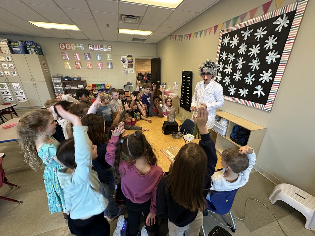 teacher dressed up as a scientist to engage kindergarten students in an experiment about magnets