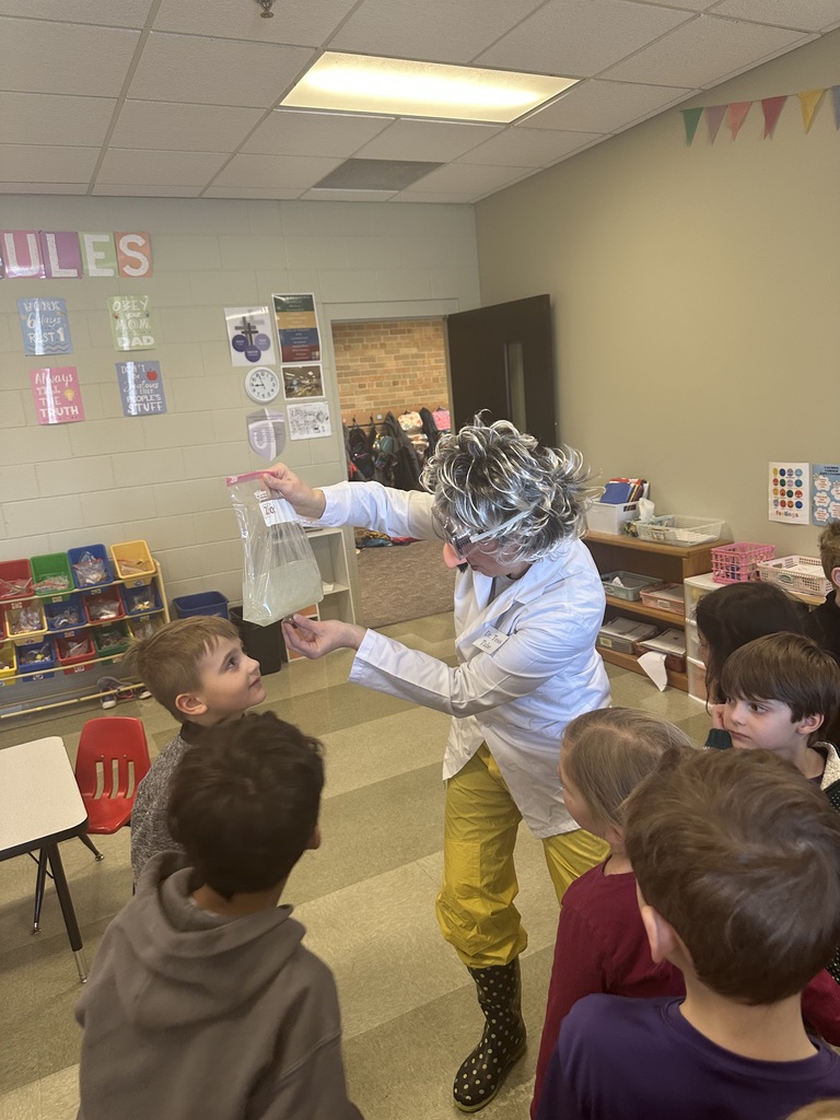 teacher dressed up as a scientist to engage kindergarten students in an experiment about magnets