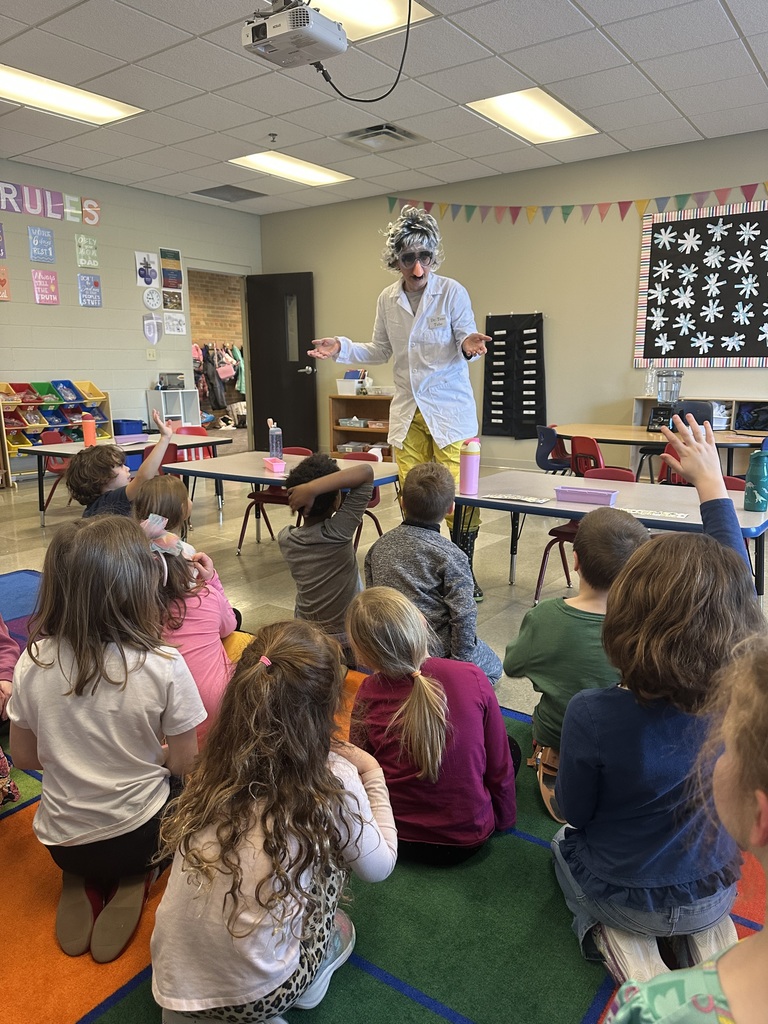 teacher dressed up as a scientist to engage kindergarten students in an experiment about magnets
