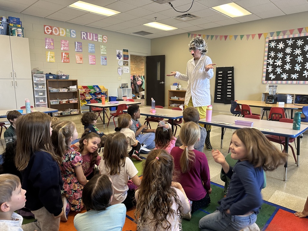 teacher dressed up as a scientist to engage kindergarten students in an experiment about magnets