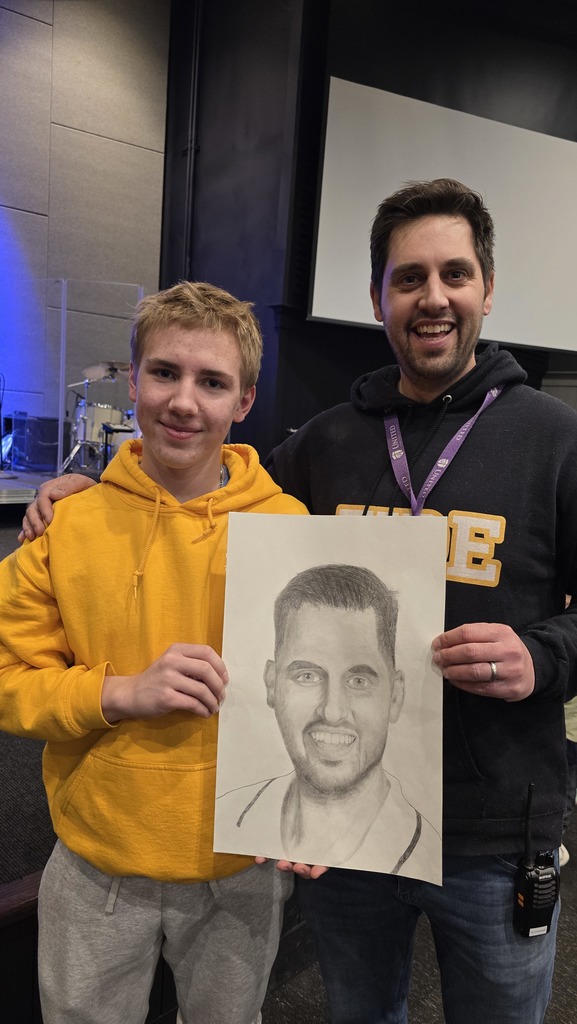 high school student standing with a high school teacher whom he drew a portrait of
