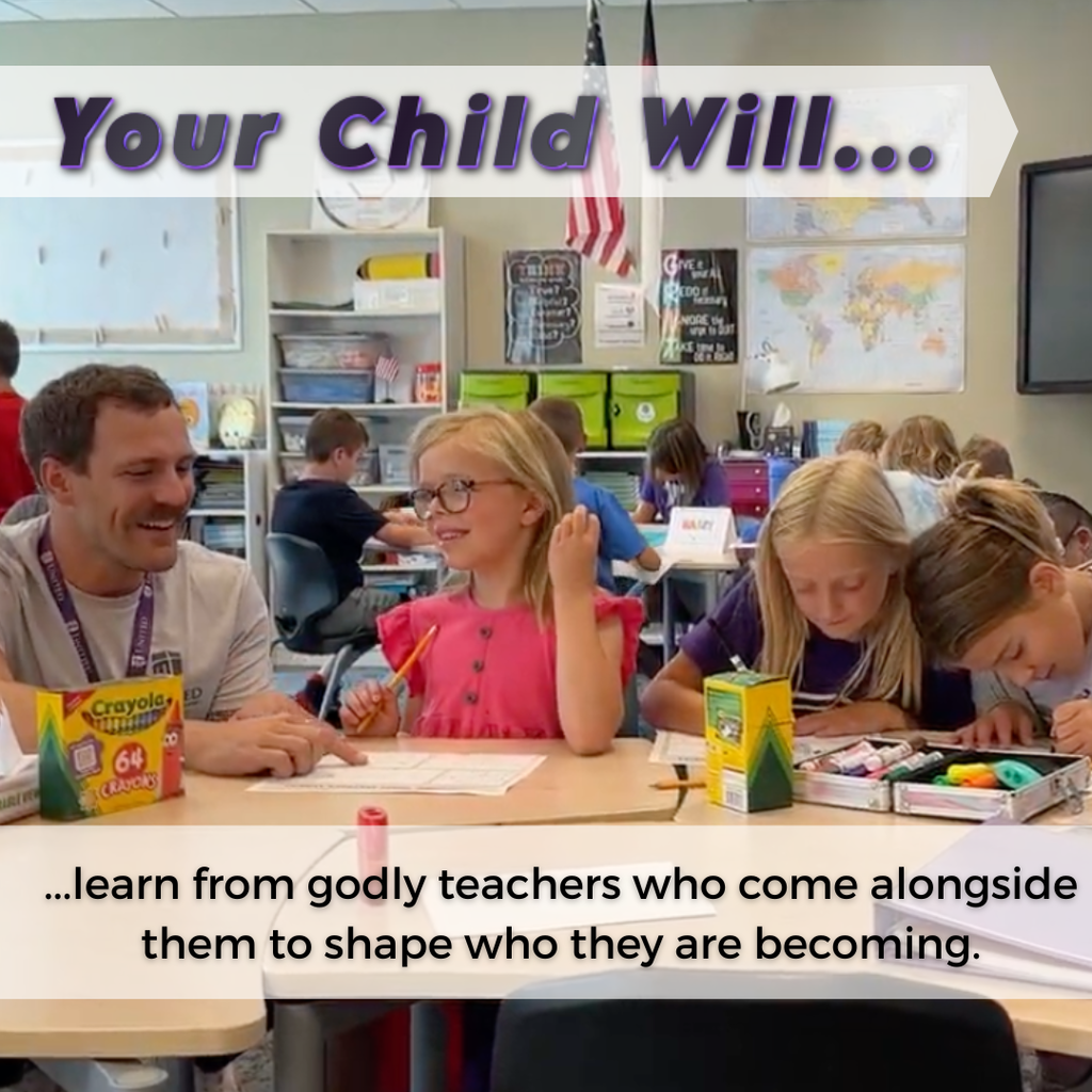 3rd grade teacher kneeling next to three of his students to help them with their work