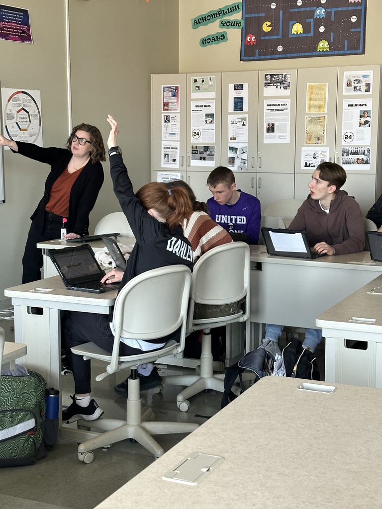 teacher  lecturing at the front of the classroom