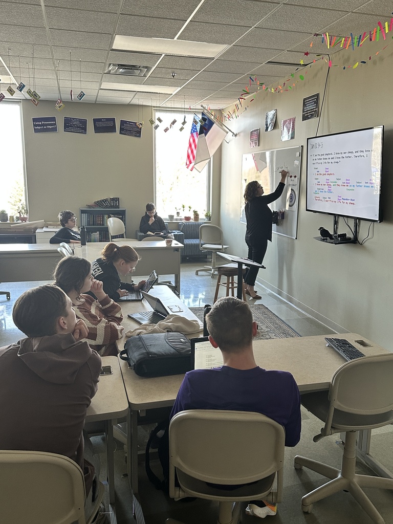 teacher  lecturing at the front of the classroom