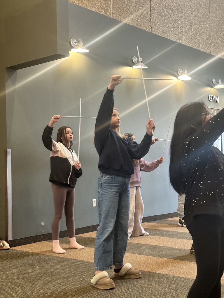sixth grade students holding white rods which they use in a choreographed song