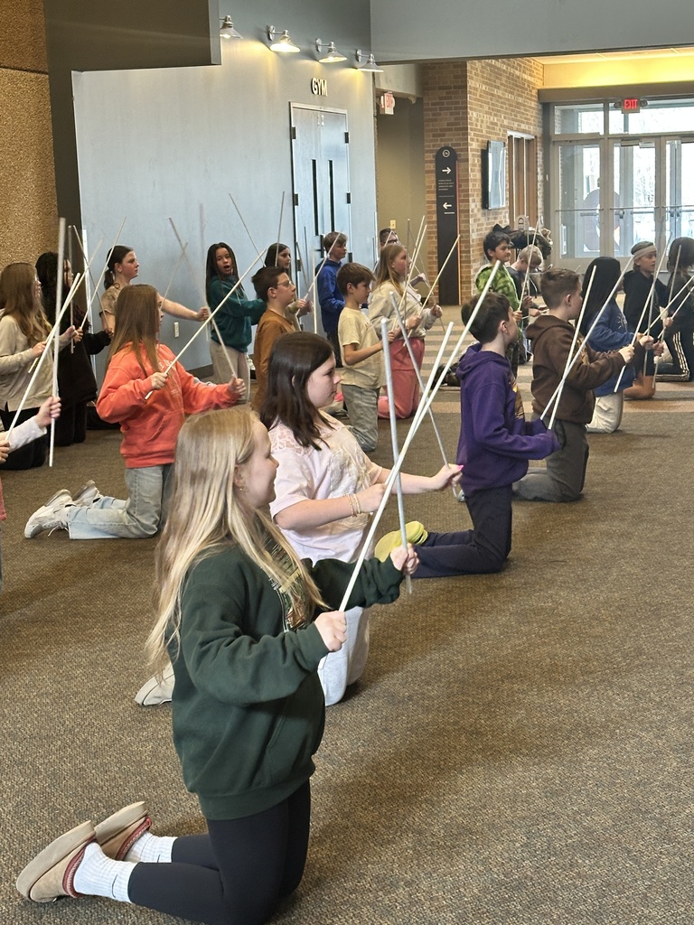 sixth grade students holding white rods which they use in a choreographed song