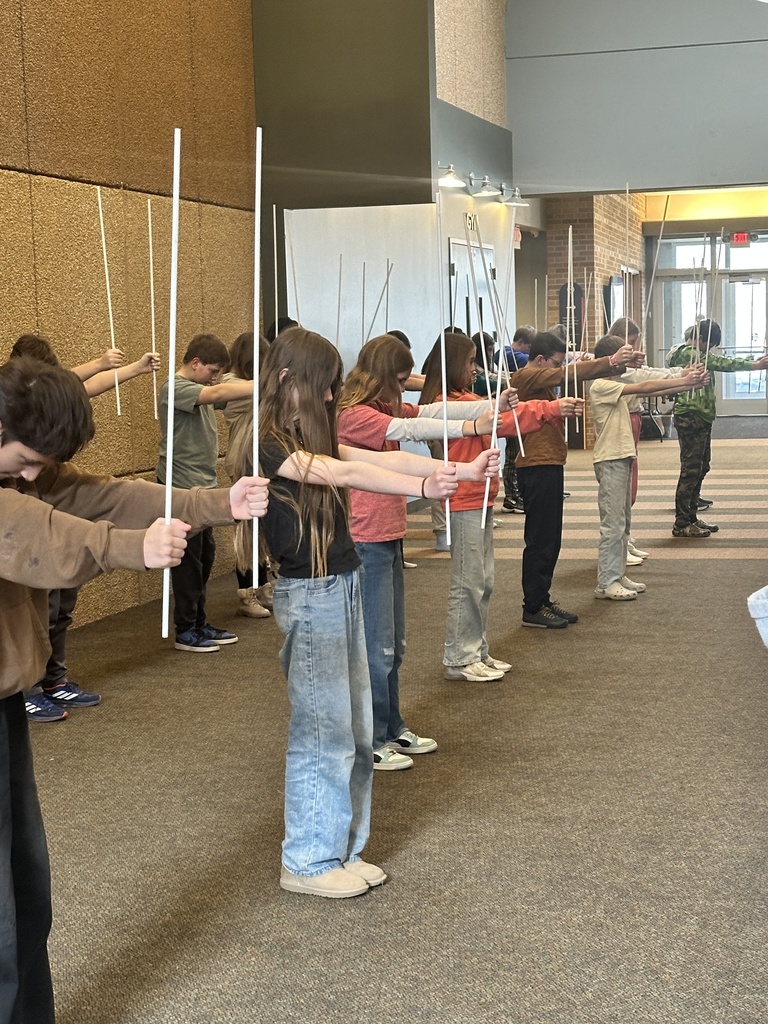 sixth grade students holding white rods which they use in a choreographed song