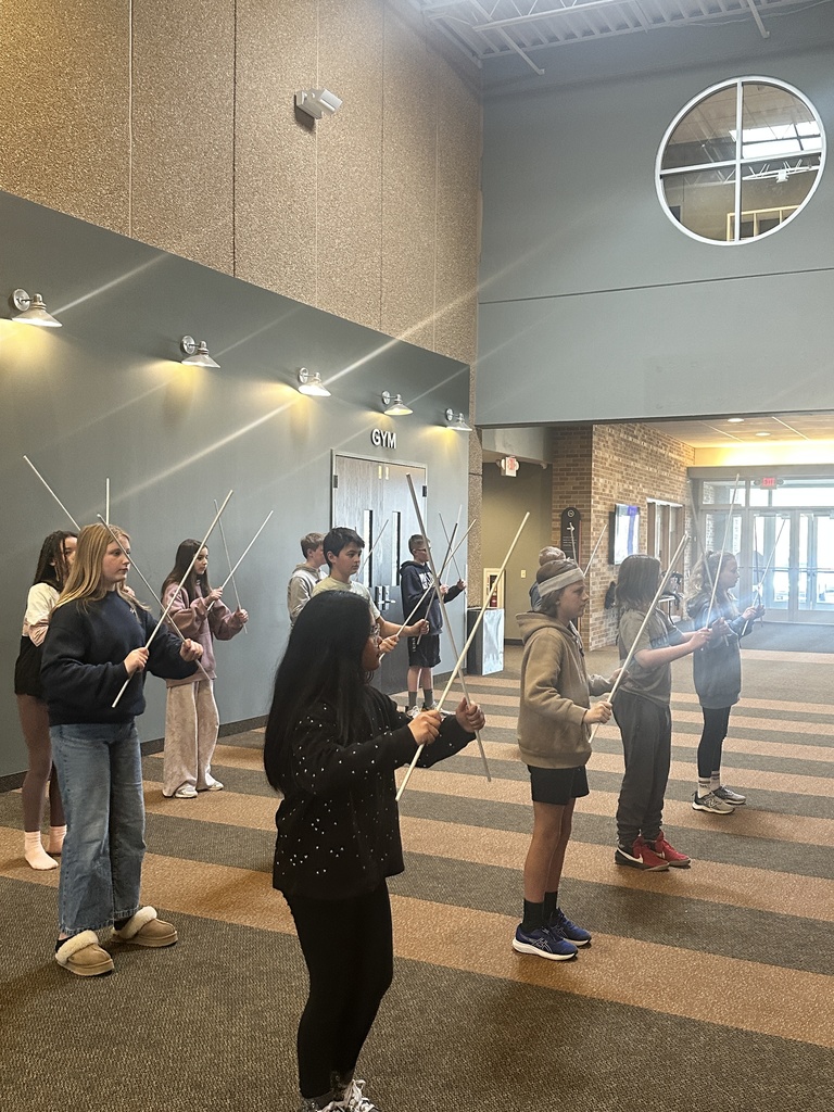 sixth grade students holding white rods which they use in a choreographed song